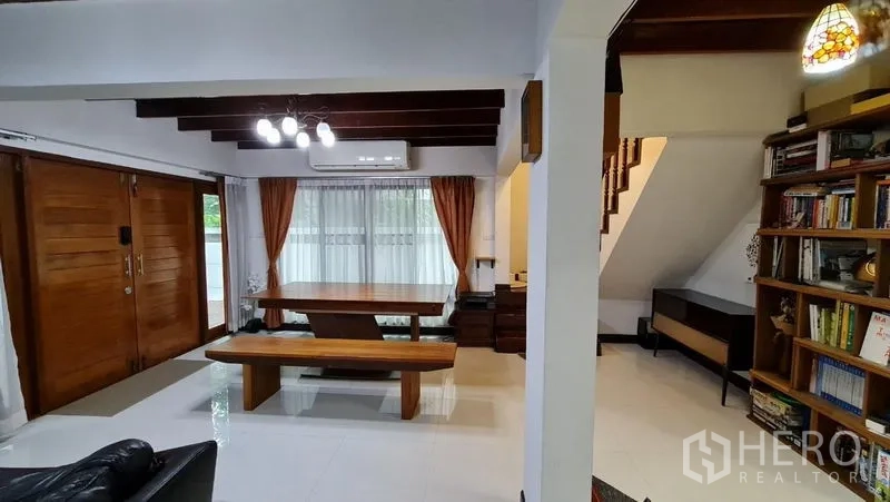Detached House for rent in Saphan Sung, Bangkok - Dining area with wooden table, exposed ceiling beams, and large sliding doors.