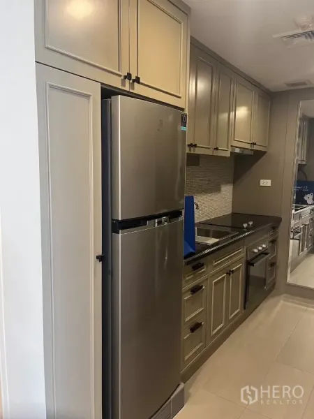 公寓 出租在Pathum Wan, Bangkok - 现代长廊式厨房，带不锈钢冰箱、嵌入式烤箱与充足柜体。