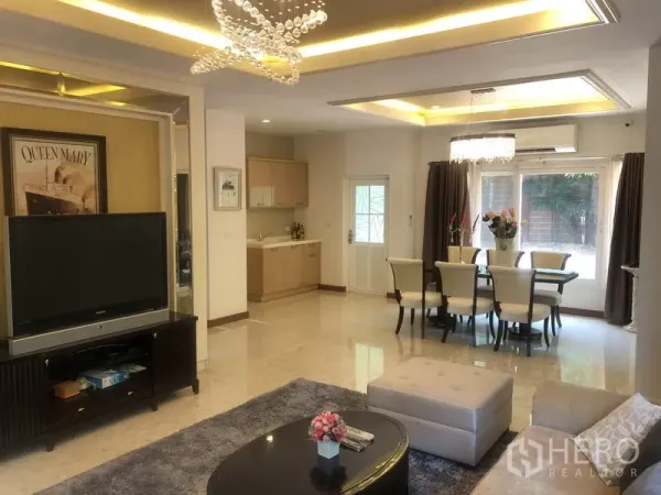 独立式住宅 出租或出售在Pak Kret, Nonthaburi - 客厅配电视柜与吊顶灯，旁设简易备餐区