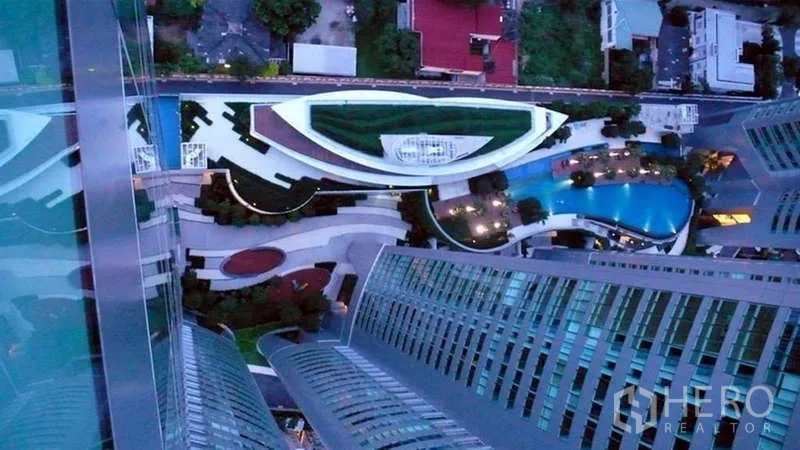 คอนโด ให้เช่าหรือขายในKhlong Toei, Bangkok - ภาพมุมสูงลงสู่โถงกลางโครงการ Millennium Residence สวนจัดแต่งและสระว่ายน้ำรูปโค้ง