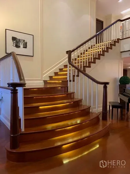 คอนโด ให้เช่าหรือขายในWatthana, Bangkok - บันไดไม้โค้งพร้อมไฟส่องใต้ขั้น และราวลูกกรงสีขาว