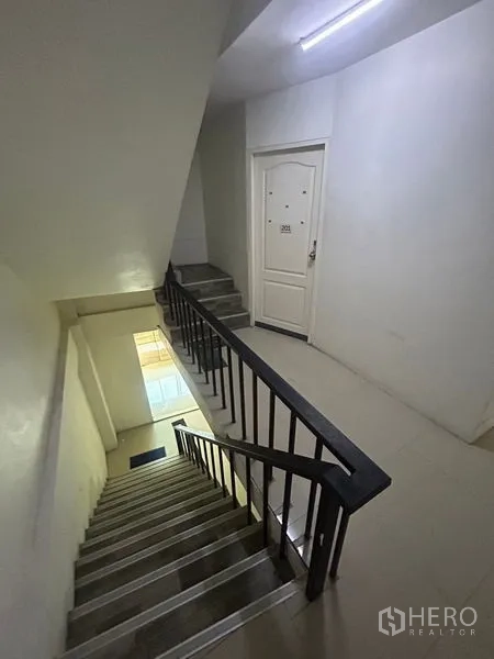 อาคารพาณิชย์ ให้เช่าในKhlong Toei, Bangkok - บันไดและโถงทางเดินพร้อมราวจับนำสู่ประตูห้องสีขาวบนชั้นพัก