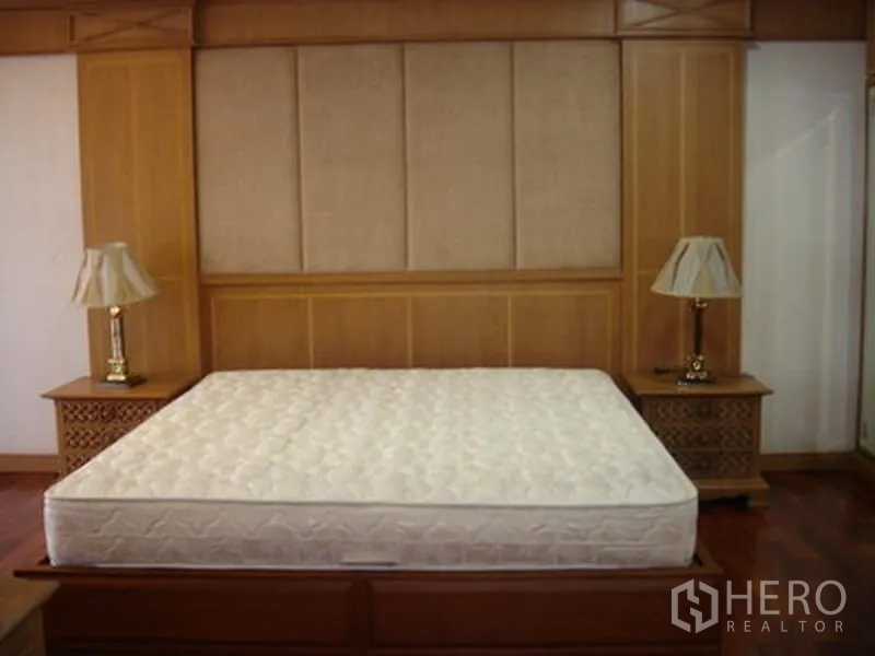 อพาร์ทเมนท์ ให้เช่าในKhlong Toei, Bangkok - ห้องนอนพร้อมหัวเตียงบุผ้า โต๊ะข้าง และงานไม้โทนอุ่น