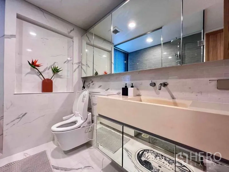 คอนโด ให้เช่า - ห้องน้ำโมเดิร์น ผนังลายหินอ่อน อ่างล้างหน้ายาว และโถสุขภัณฑ์อัตโนมัติ