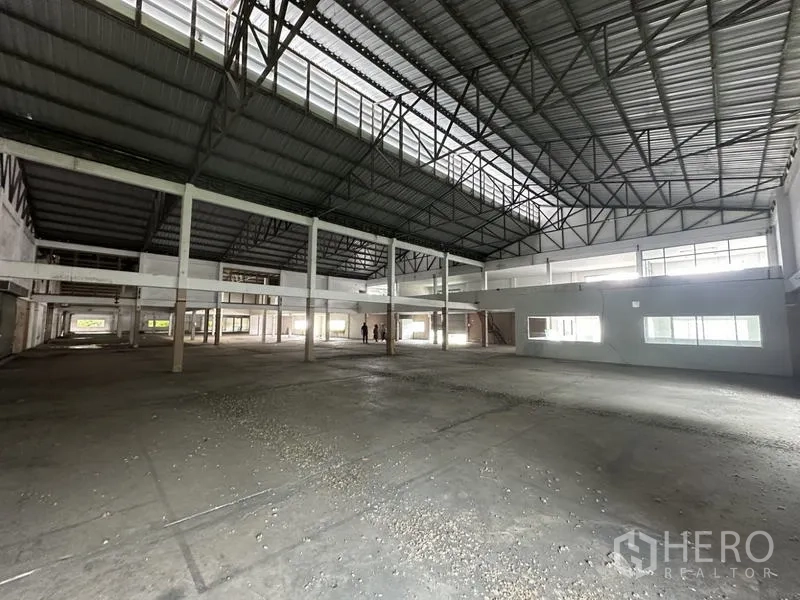 Factory for rent or sale in Khlong Luang, Pathum Thani - Large factory interior showing high ceilings, skylights and office mezzanine.