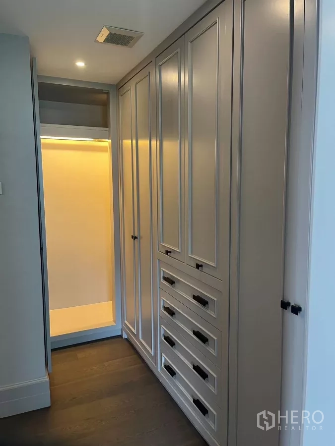 公寓 出租在Pathum Wan, Bangkok - 步入式衣帽间，高柜与抽屉配柔和灯光。