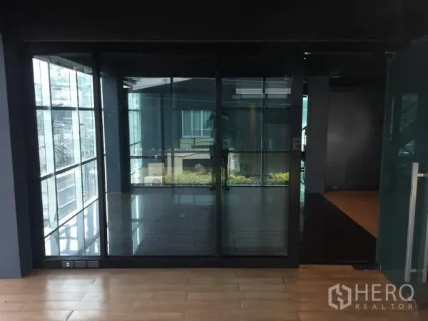 零售空间 出租在Khlong Toei, Bangkok - 整面落地玻璃房间，可见小型露台与室外景观。