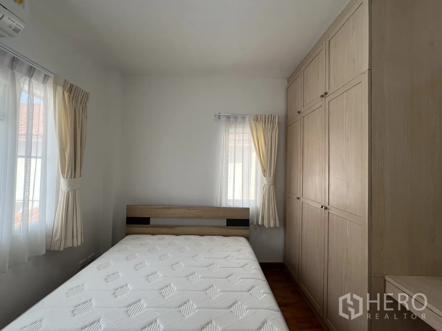 Detached House for rent in Bang Kapi, Bangkok - Bright bedroom with bed, large wardrobe and two windows.