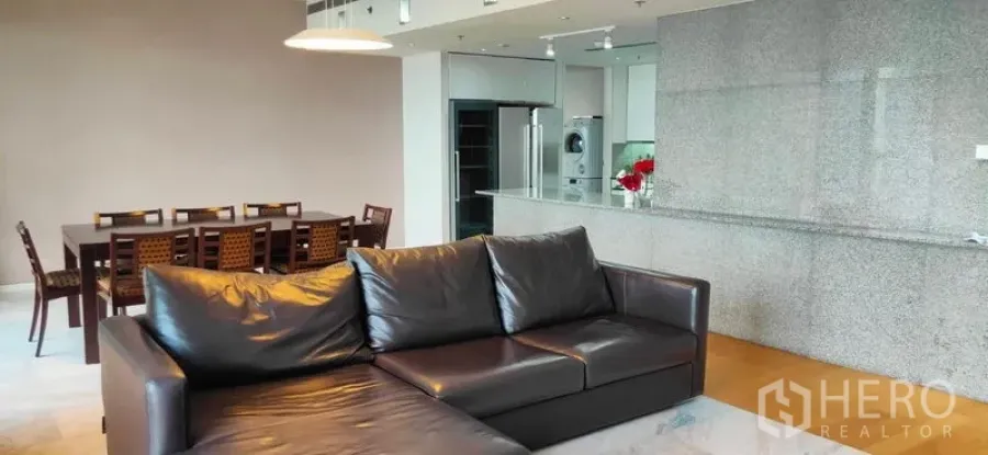 公寓 出售在Sathon, Bangkok - 开放式客餐厅，黑色皮沙发、长餐桌与花岗岩吧台