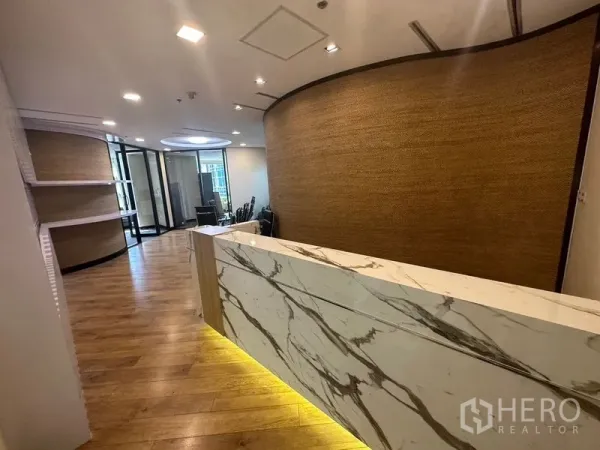 办公空间 出租 - 现代化前台，带大理石接待台、木地板与弧形装饰墙。
