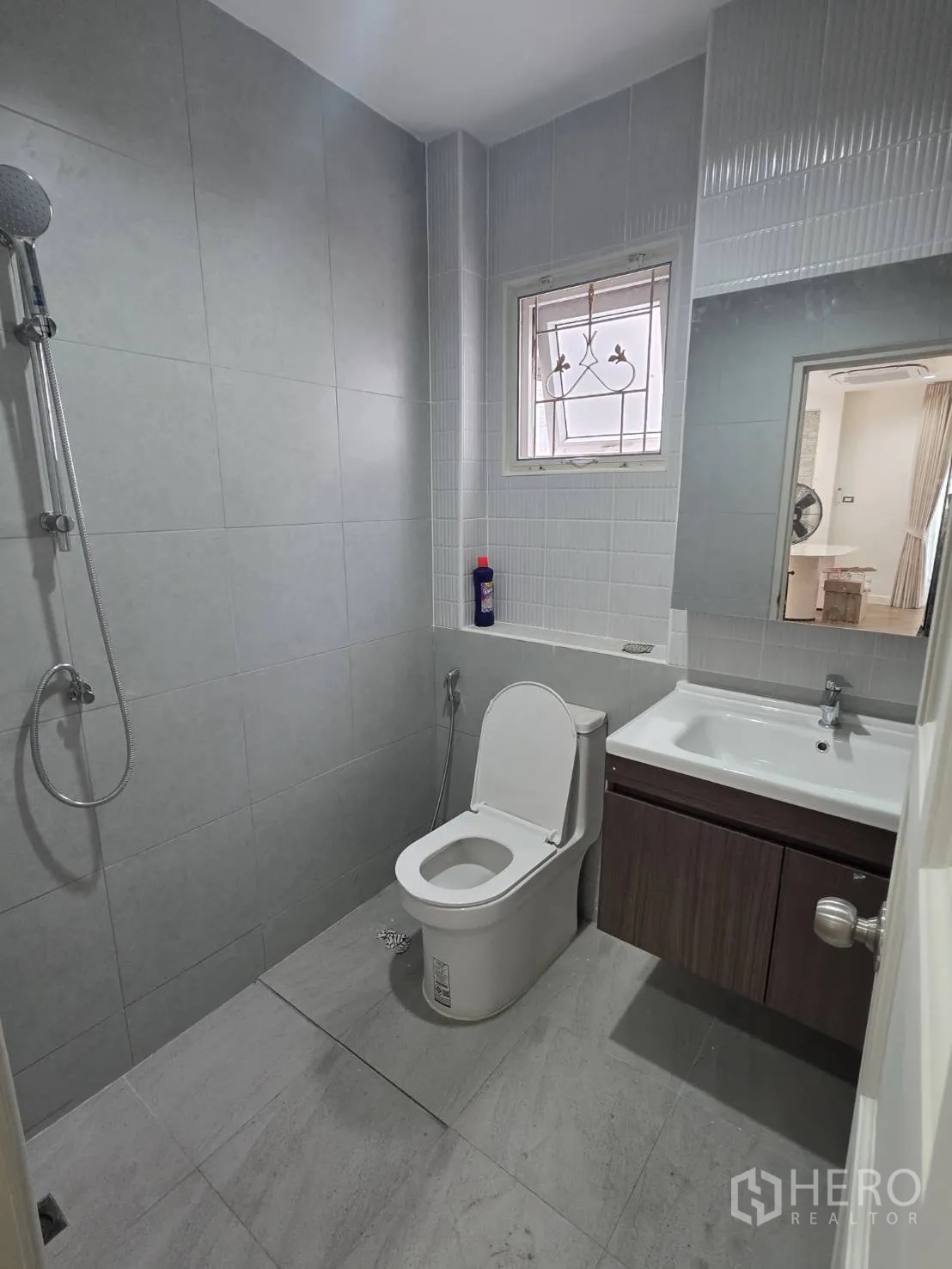 Detached House for sale in Lam Luk Ka, Pathum Thani - Modern bathroom with walk-in shower, toilet, and vanity set against gray tiles.