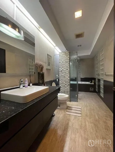 Townhouse for rent in Phaya Thai, Bangkok - Contemporary bathroom with long vanity, glass shower, and bathtub.