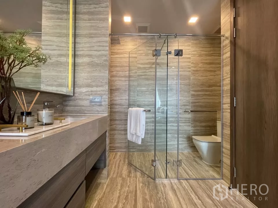 Condominium for rent in Watthana, Bangkok - Large bathroom featuring double vanity and frameless glass shower enclosure.