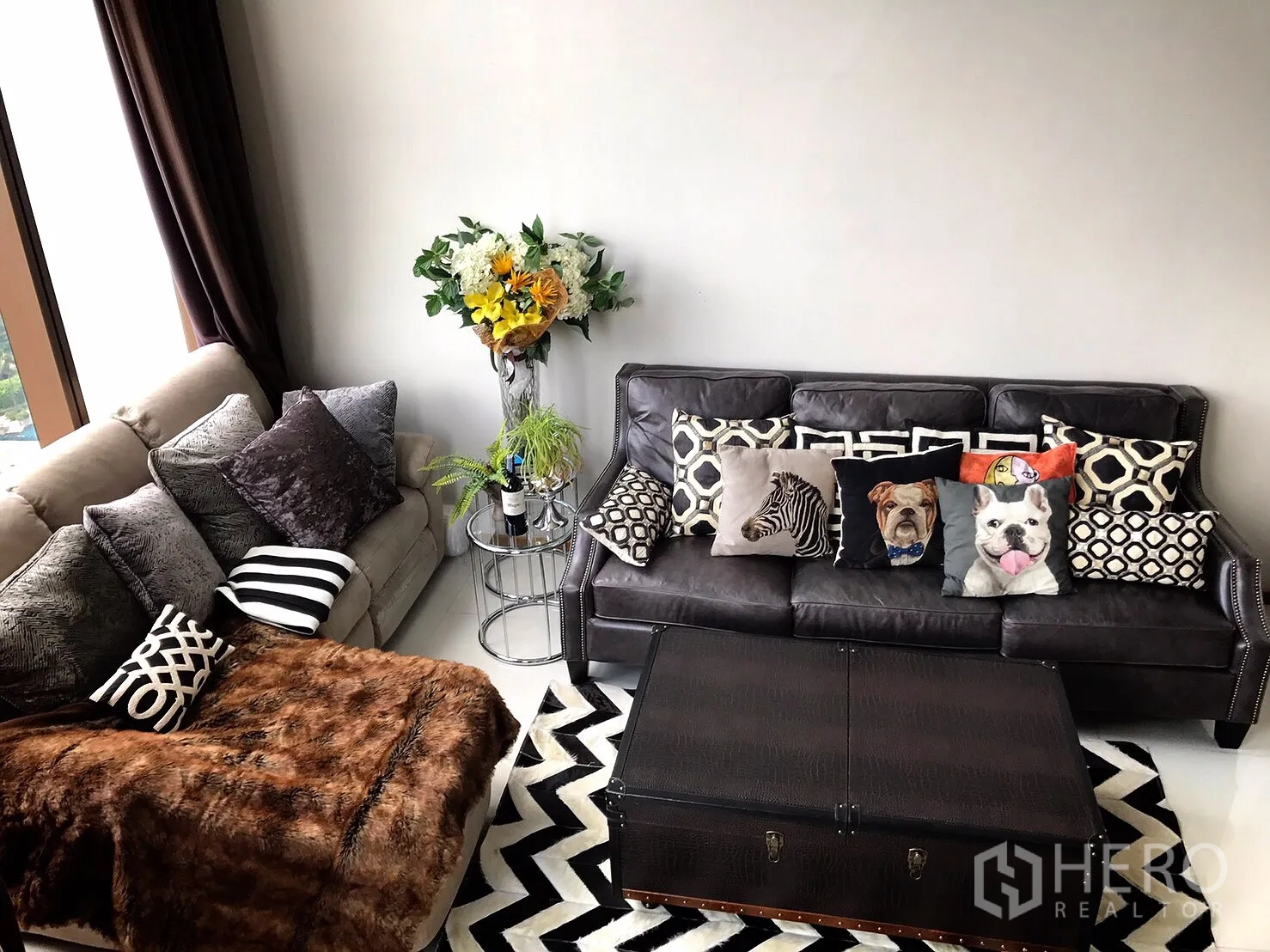 คอนโด ให้เช่าหรือขายในKhlong Toei, Bangkok - ห้องนั่งเล่นมีโซฟาสองชุด หมอนลายกราฟิก พรมลายซิกแซก และโต๊ะกลางทรงหีบ