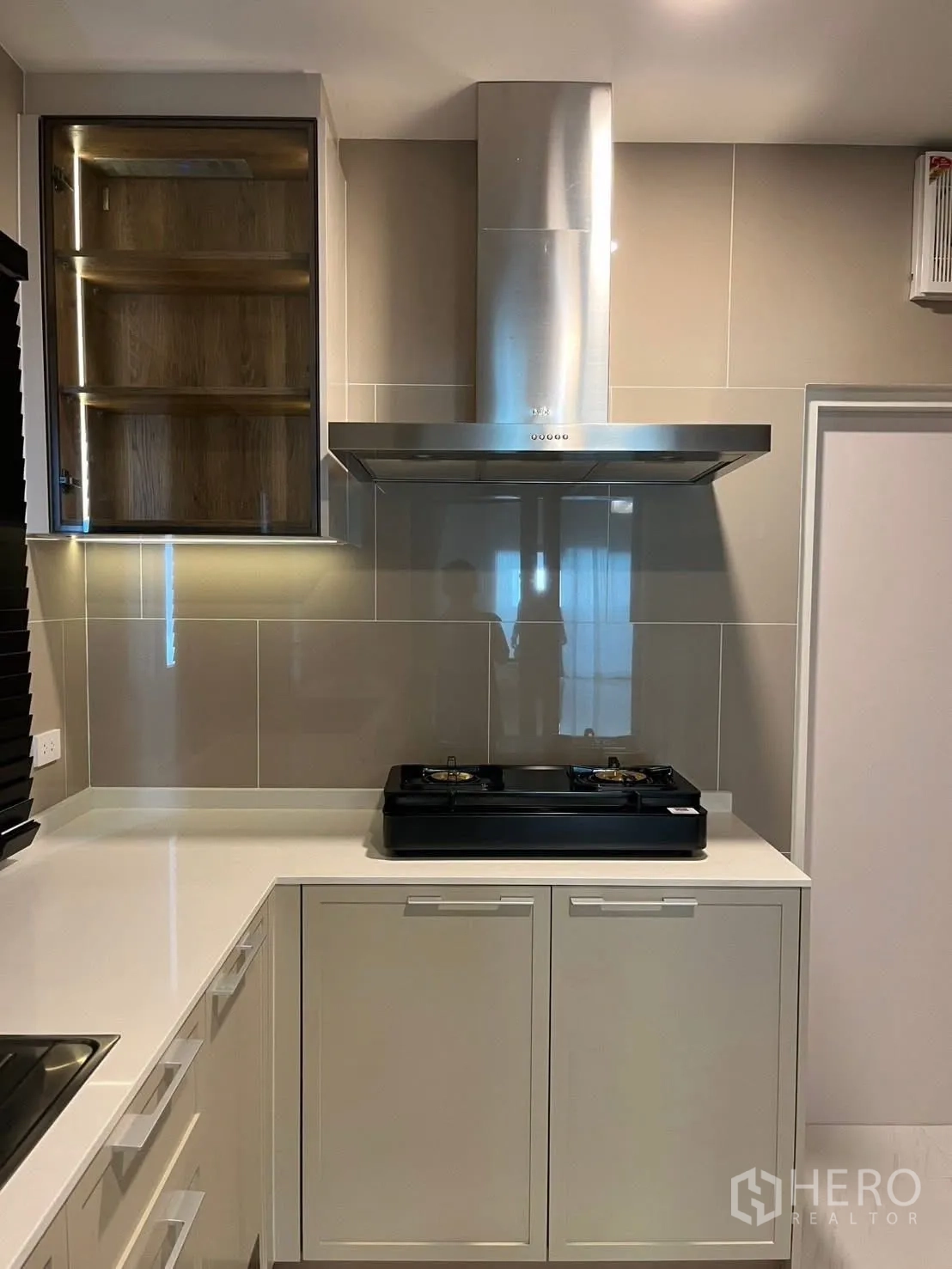 Detached House for rent in Bang Phli, Samut Prakan - Close-up of gas stove and stainless steel range hood on glossy tile backsplash.