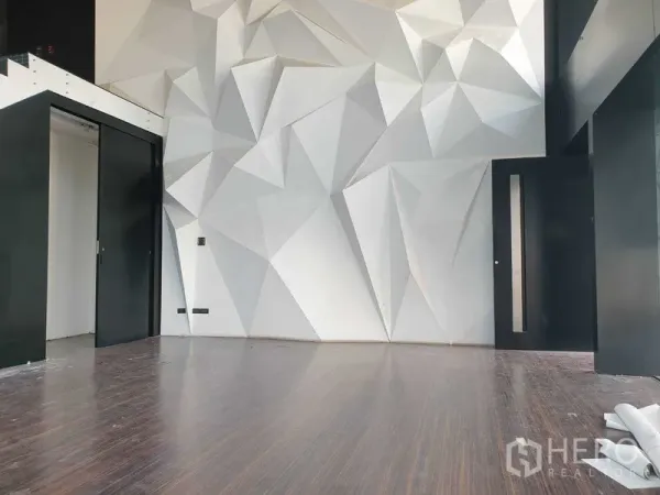 零售空间 出租在Khlong Toei, Bangkok - 展厅近景：立体几何墙面与黑色推拉门。