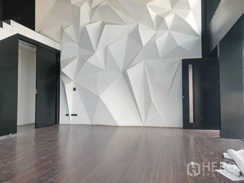 零售空间 出租在Khlong Toei, Bangkok - 展厅近景：立体几何墙面与黑色推拉门。