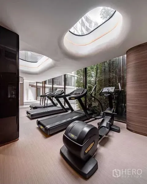 Condominium for rent - Fitness room with treadmills and an elliptical under skylights overlooking a garden.