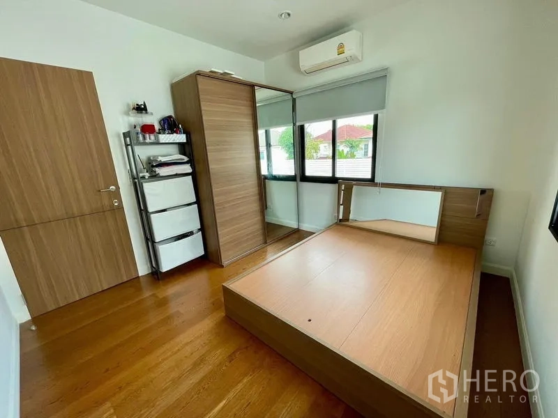Detached House for rent in Phasi Charoen, Bangkok - Third bedroom with platform bed, mirrored wardrobe and hardwood floor.