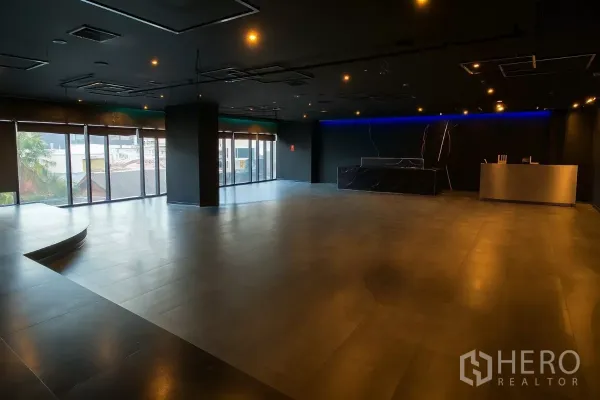 零售空间 出租 - 转角空间，弧形平台、顶灯与城市景观窗。