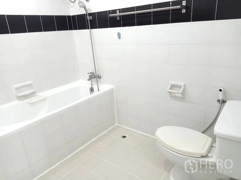 คอนโด for rent in Watthana, Bangkok - ห้องน้ำปูกระเบื้องสีขาวพร้อมอ่างอาบน้ำ ฝักบัว และโถสุขภัณฑ์