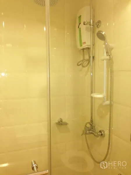 Condominium for rent or sale in Mueang Samut Prakan, Samut Prakan - Enclosed shower with rain head and electric water heater on tiled wall.