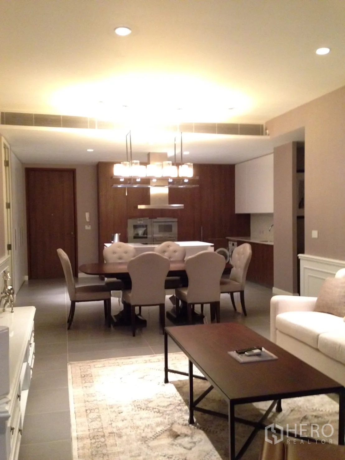 คอนโด ให้เช่าหรือขายในPathum Wan, Bangkok - พื้นที่นั่งเล่นและรับประทานอาหารแบบเปิด โต๊ะทานข้าว 6 ที่ โคมแชนเดอเลียร์ และครัวด้านหลัง.