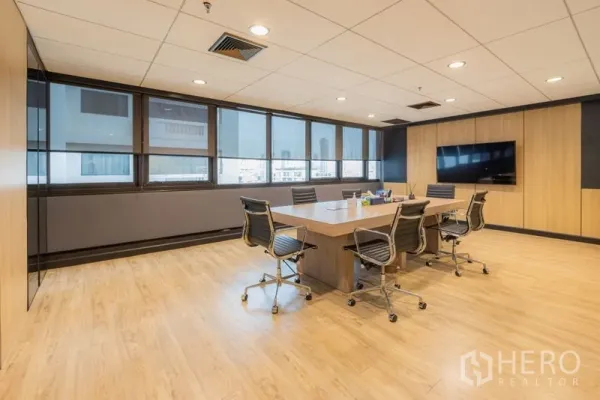 Office Space for rent - Boardroom with large table, swivel chairs, TV screen and city-view windows.