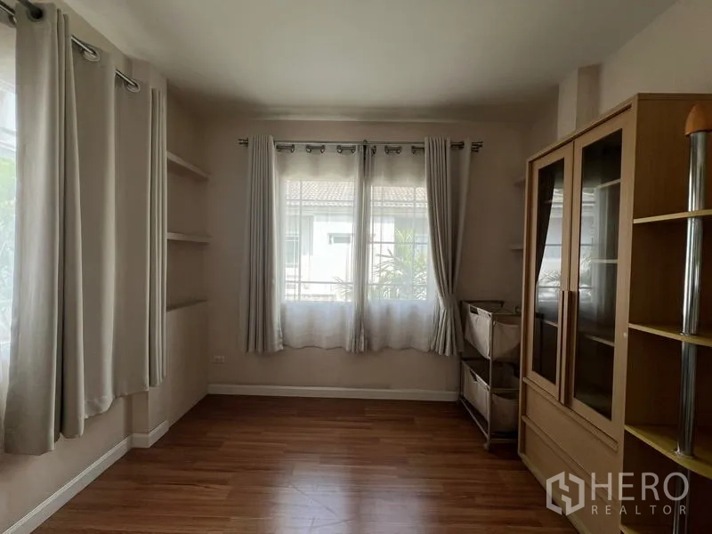 บ้าน ให้เช่าในBang Kapi, Bangkok - ห้องมุมโล่งพร้อมผ้าม่าน ชั้นวาง และตู้โชว์