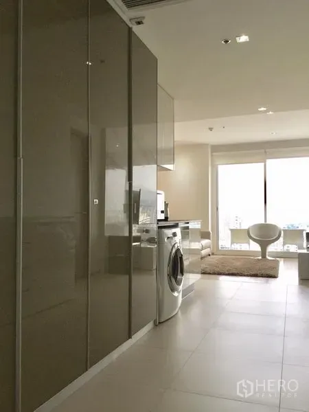 คอนโด ให้เช่าหรือขายในWatthana, Bangkok - มุมมองทางเดินผ่านครัวบิวท์อินสู่ห้องนั่งเล่นที่ได้รับแสงธรรมชาติ