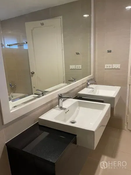 Detached House for rent in Bang Phli, Samut Prakan - Modern bathroom with double square basins, a large mirror, and beige tiled walls.