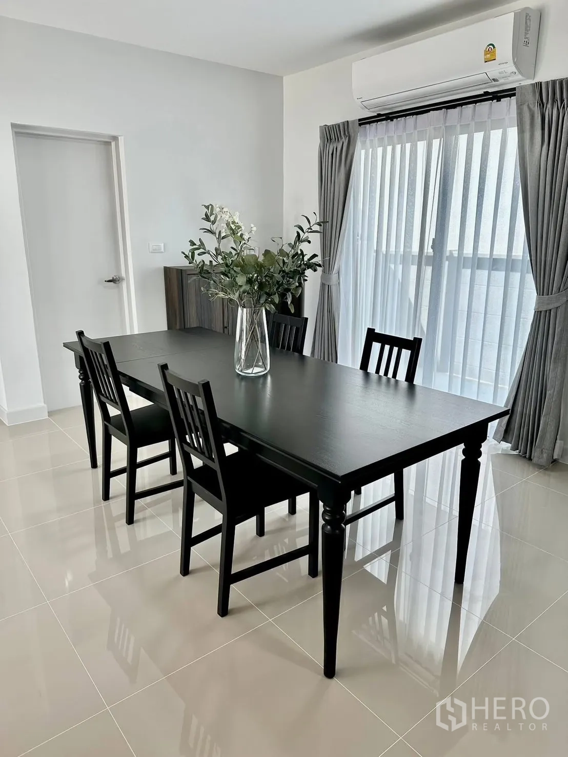 Townhouse for rent in Bang Phli, Samut Prakan - Spacious living-dining area with TV unit, staircase, and large windows.