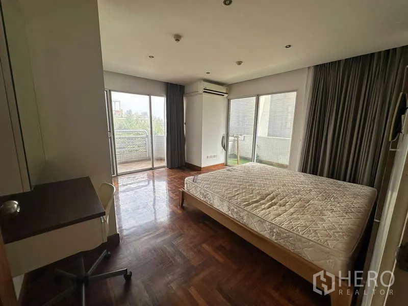 คอนโด ให้เช่าในWatthana, Bangkok - ห้องนอนมาสเตอร์ มีหน้าต่างกว้าง ประตูออกระเบียงสองด้าน และโต๊ะทำงาน