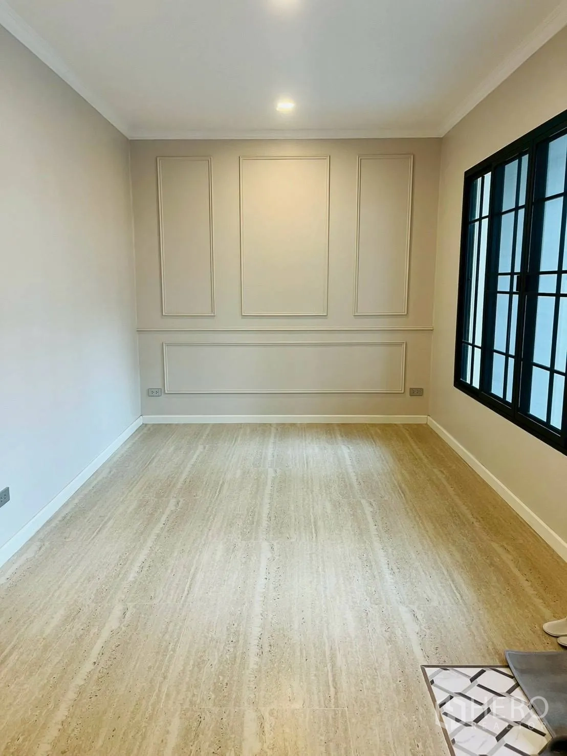 ทาวน์เฮาส์ for rent in Khlong Toei, Bangkok - ห้องสว่างผนังตกแต่งบัวปูน หน้าต่างกรอบดำบานใหญ่ และพื้นลายไม้.