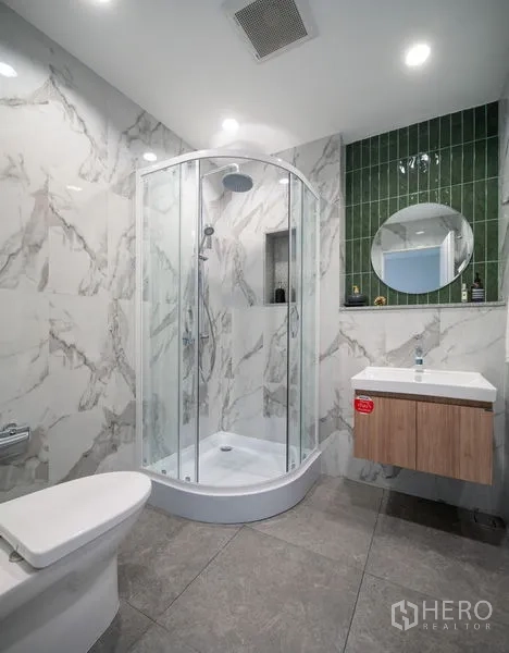 Townhouse for sale in Din Daeng, Bangkok - Modern bathroom with glass shower enclosure, marble-look tiles and floating vanity.