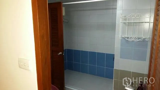 Condominium for rent in Watthana, Bangkok - Tiled bathroom with walk-in shower and wooden louver door.