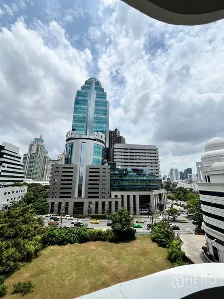 Condominium for rent in Ratchathewi, Bangkok - City view from the balcony overlooking modern glass office towers and green space in Ratchathewi.