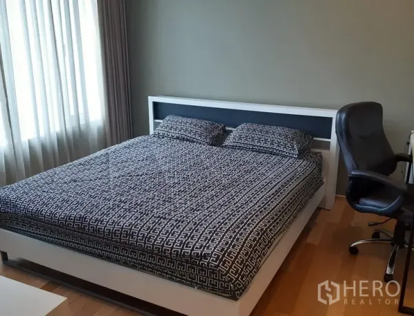 คอนโด ให้เช่าในKhlong Toei, Bangkok - ห้องนอนเตียงใหญ่ พื้นไม้ พร้อมโต๊ะทำงานและแสงธรรมชาติผ่านผ้าม่าน