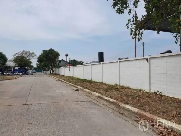 货栈 出租在Nakhon Pathom - 园区内沿白色围墙的通行道路，安全封闭环境。