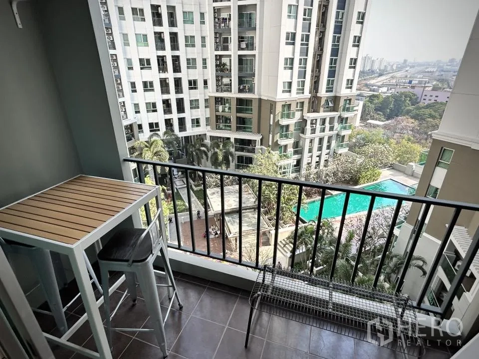 คอนโด for rent in Huai Khwang, Bangkok - ระเบียงพร้อมโต๊ะและม้านั่ง มองเห็นสระว่ายน้ำและสวนส่วนกลาง