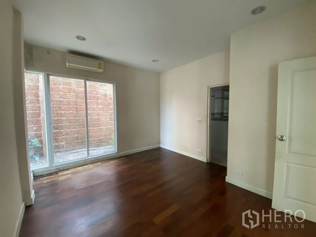 บ้าน ให้เช่าหรือขายในLak Si, Bangkok - ห้องนอนชั้นล่าง ประตูกระจกบานเลื่อนไปสวนข้างบ้าน พร้อมทางเข้าห้องน้ำ.