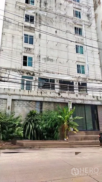 สำนักงาน ให้เช่าในPrawet, Bangkok - ด้านหน้าตึกพาณิชย์หลายชั้น ชั้นล่างมีประตูม้วนและต้นไม้หน้าร้าน ในเขตประเวศ กรุงเทพฯ