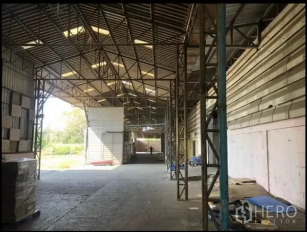 Factory for rent in Bang Khla, Chachoengsao - High-ceiling warehouse interior featuring steel trusses and natural skylights.