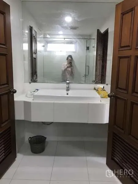 คอนโด ขายในWatthana, Bangkok - โซนอ่างล้างหน้า พร้อมกระจกบานใหญ่ ซิงก์ และประตูไม้บานคู่