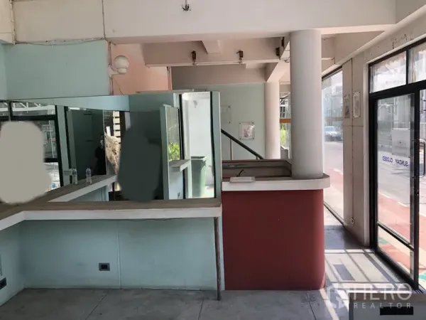 零售空间 出租在Khlong Toei, Bangkok - 一层展厅内部，通透玻璃墙、接待台与临街入口。