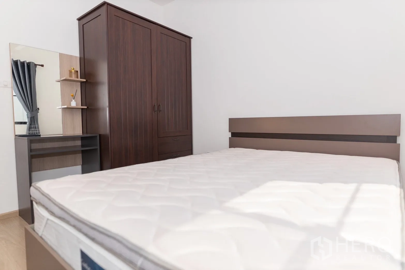 Townhouse for rent in Bang Phli, Samut Prakan - Bedroom with double bed, dark wood wardrobe, and dressing table.