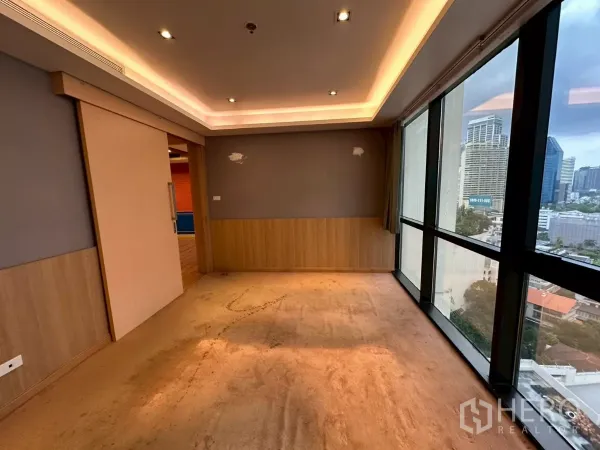 Office Space for rent in Khlong Toei, Bangkok - Corner executive room with sliding door, cove lighting, and city views.