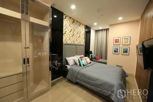 คอนโด ให้เช่าหรือขายในWatthana, Bangkok - ห้องนอนหัวเตียงบุผ้า ผนังลายกราฟิก และตู้เสื้อผ้าบิลท์อิน