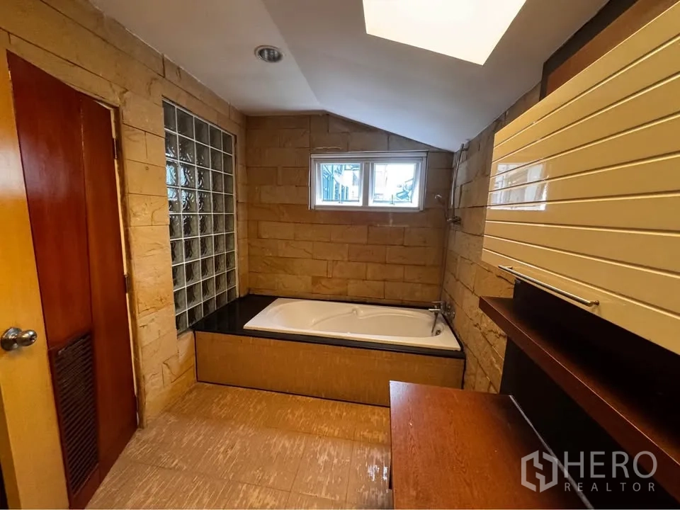 ทาวน์เฮาส์ for rent in Huai Khwang, Bangkok - ห้องน้ำมีอ่างอาบน้ำบิวท์อิน หน้าต่างบานเล็ก และผนังกระเบื้องลายหิน.