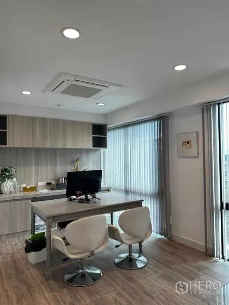 Home Office for rent in Bueng Kum, Bangkok - Bright executive workspace with built-in cabinets, desk, and vertical blinds.